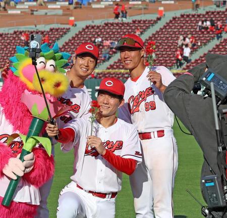 カーネーションを手に写真に納まる赤木（前列）と（後列右から）二俣、塹江（撮影・北村雅宏）