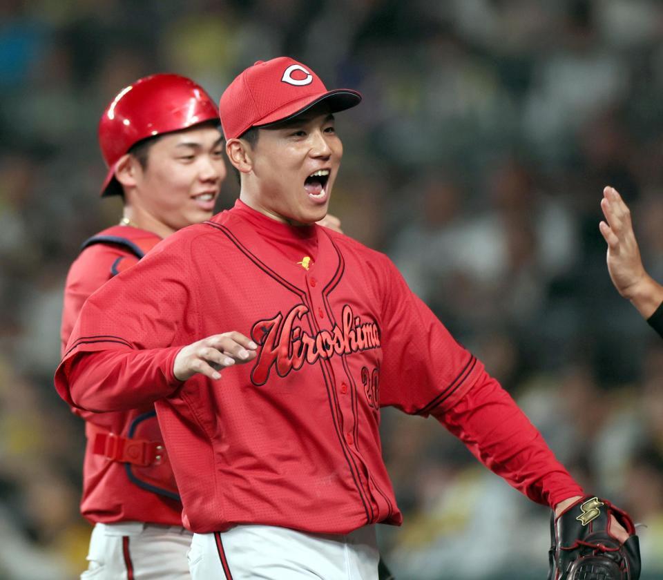６回、阪神打線を無失点に抑え、勢いよくベンチへ戻る栗林と持丸（奥）のバッテリー（撮影・田中太一）