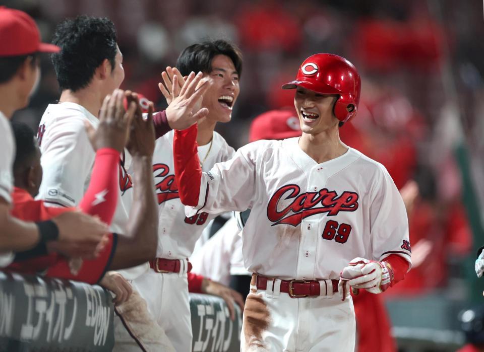 ９回、名原の同点適時打で生還し、ナインとタッチを交わす代走・辰見（撮影・北村雅宏）