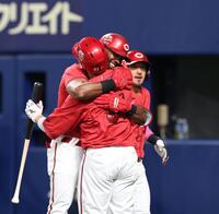 ６回、逆転となる３ランを放ち、坂倉（手前）と抱き合うファビアン（撮影・北村雅宏）