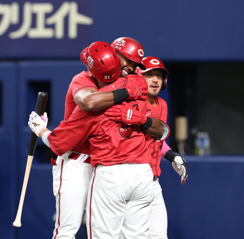 ６回、逆転となる３ランを放ち、坂倉（手前）と抱き合うファビアン（撮影・北村雅宏）