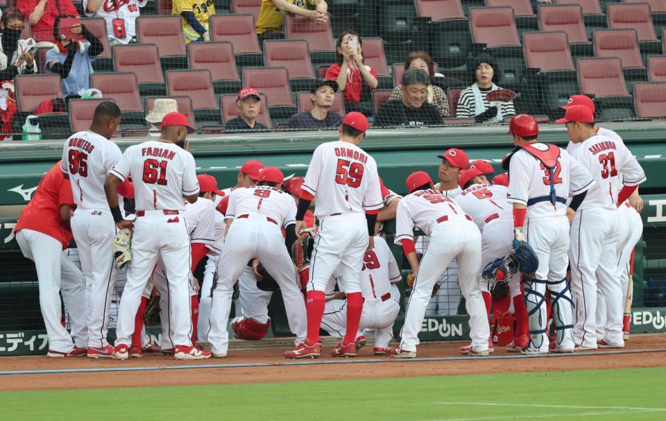 試合前、ベンチ前で円陣を組む広島ナイン（撮影・山口登）