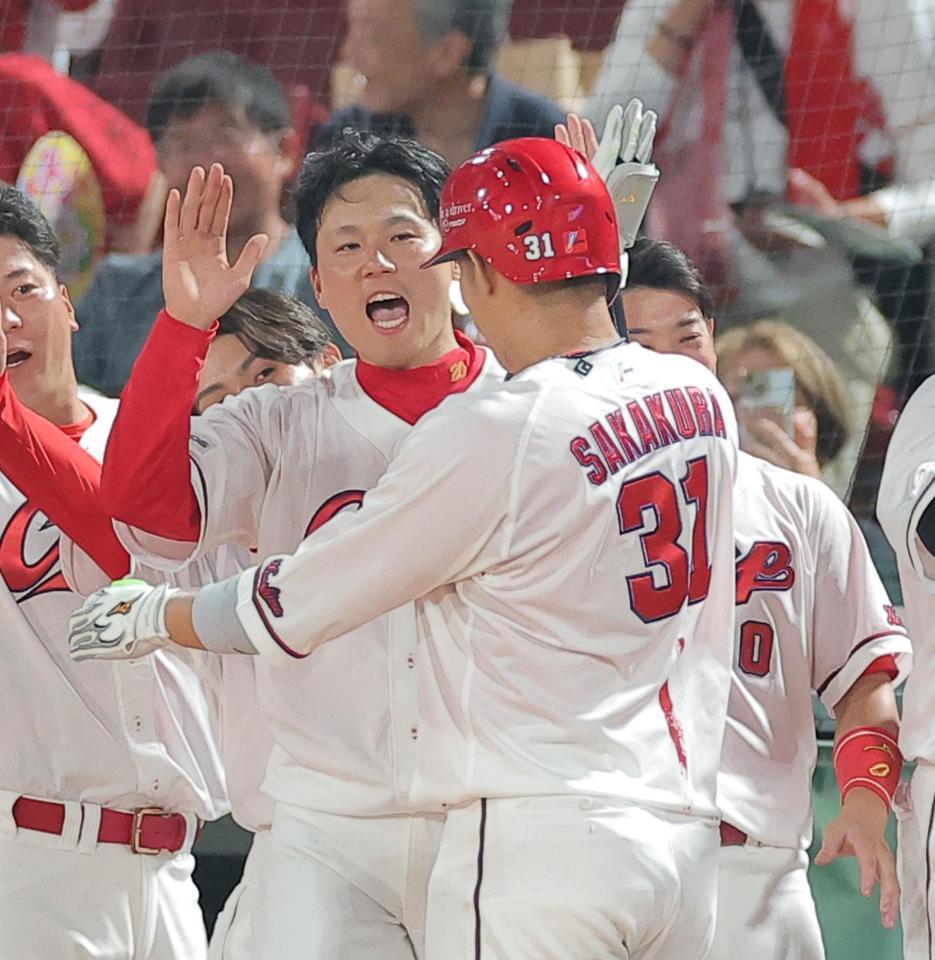 ６回、勝ち越しソロを放った坂倉（右）を笑顔で迎える栗林（撮影・西田忠信）
