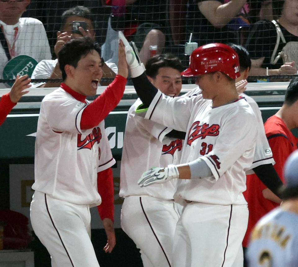 ６回、勝ち越しソロを放った坂倉を迎える栗林（左）＝撮影・山口登