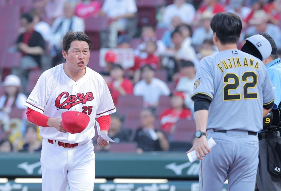 藤川監督とのメンバー表交換に向かう新井監督（撮影・西田忠信）
