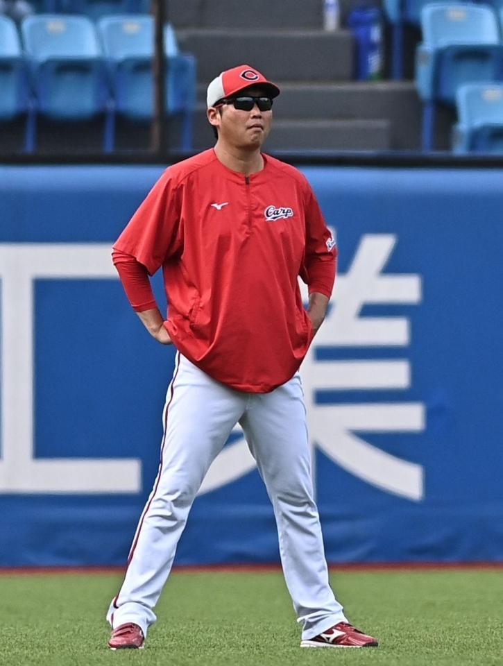 外野で試合前の練習を見守る新井監督（撮影・開出牧）