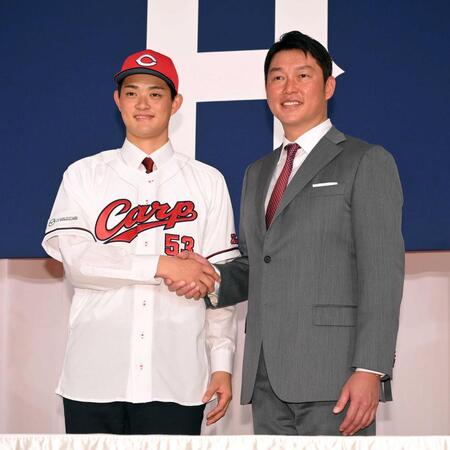 新入団会見で新井監督（右）と握手をする岡本＝２４年