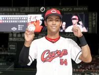 初安打のボールを手にポーズをとる西川