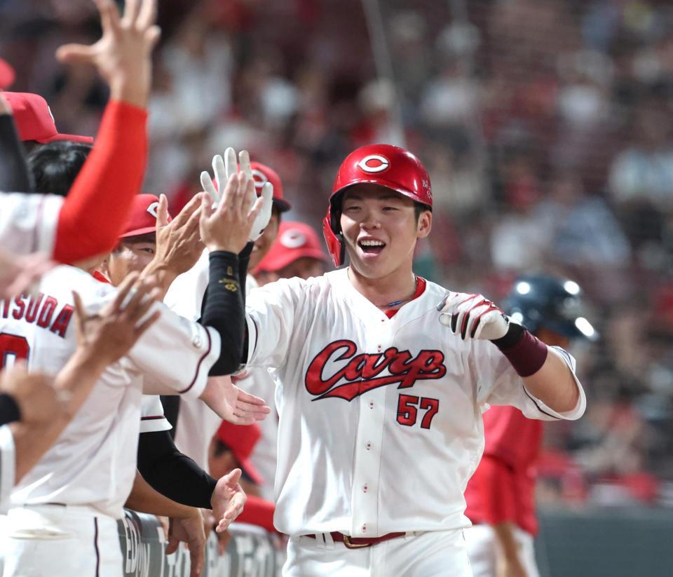 ４回、ソロを放ちナインとタッチを交わす持丸（撮影・北村雅宏）