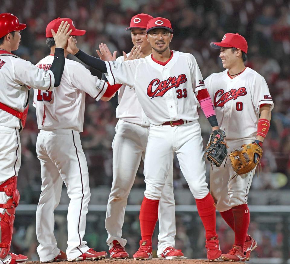 連敗がストップし、ナインと勝利のタッチを交わす菊池（中央）＝撮影・北村雅宏