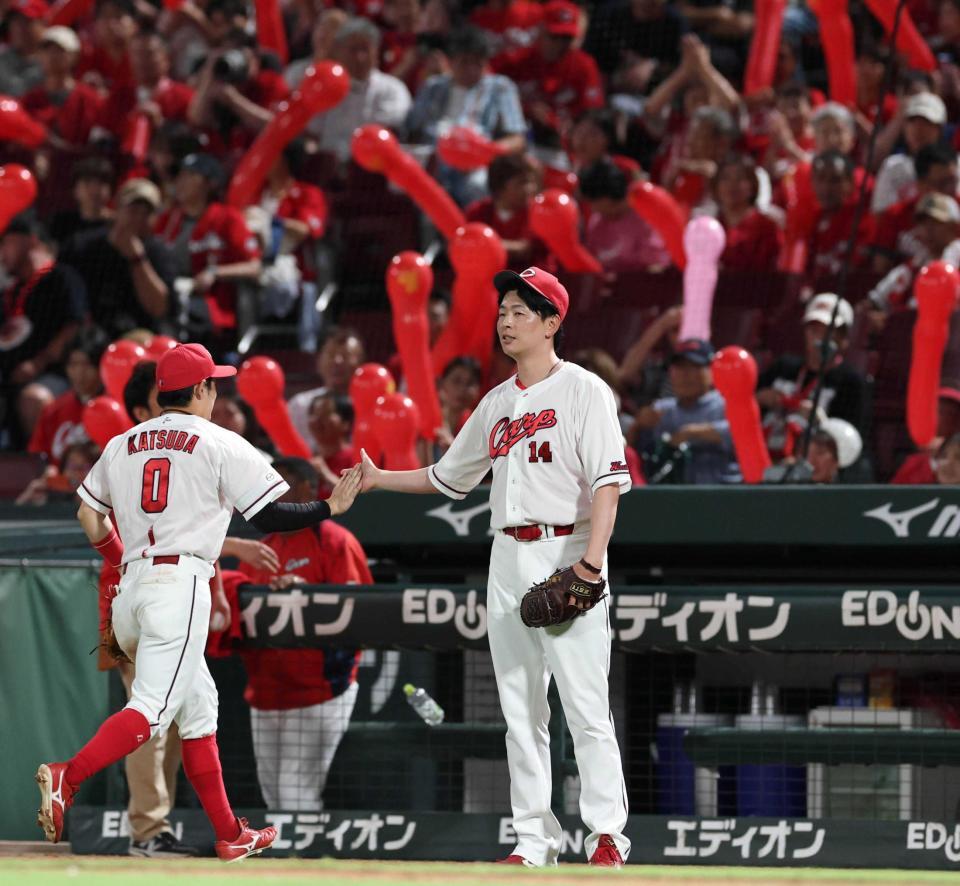 ７回、無失点で切り抜け、勝田（左）とタッチを交わす大瀬良