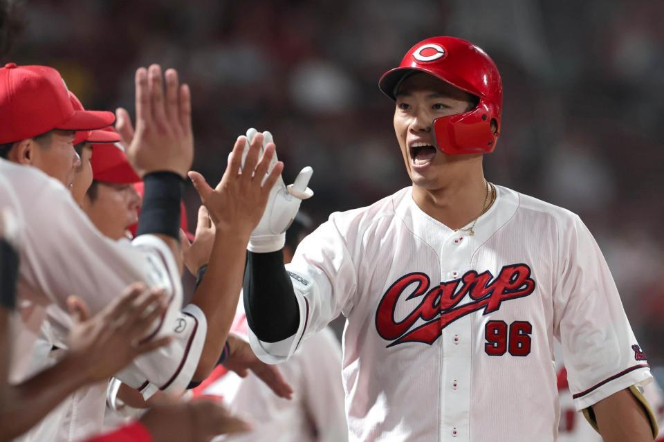 ３回、先制となる２ランを放ち、ナインとタッチを交わす中村奨（撮影・北村雅宏）