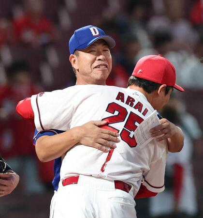 試合前、広島・新井監督と抱擁を交わす中日・井上監督（奥）＝１日