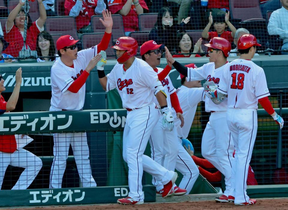 ３回、同点３ランを放った末包（中央左）とタッチを交わす新井監督（撮影・立川洋一郎）
