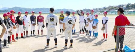 昨年のカープジュニア選手（５６、４２番）から激励を受けるカープジュニアの選手たち。右は天谷監督