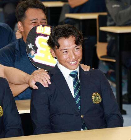 広島からドラフト１位指名され、笑顔を見せる亜大・山里宝（撮影・伊藤笙子）