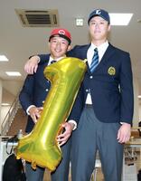 ドラフト１位指名され、笑顔を見せる広島１位の亜大・山里宝（左）と西武１位・川尻啓人（撮影・伊藤笙子）