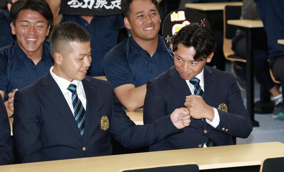 広島にドラフト１位で指名され、前嶋藍（左）とグータッチする亜大・山里宝（撮影・伊藤笙子）