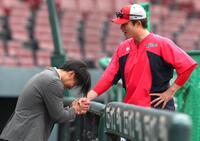 戦力外通告された後、新井良太コーチと握手を交わす中村貴浩（左）＝撮影・北村雅宏