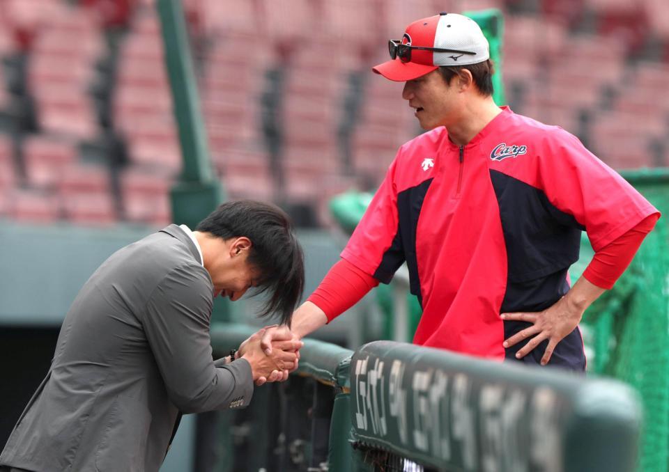 戦力外通告された後、新井良太コーチと握手を交わす中村貴浩（左）＝撮影・北村雅宏