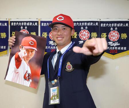 新井監督のサインが入ったドラフト会議のＩＤをかけ、笑顔を見せる広島５巡目指名の明大・光弘帆高（撮影・吉澤敬太）