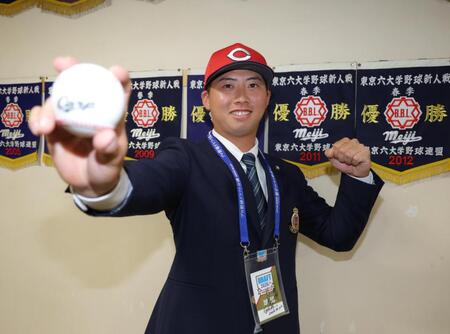新井監督のサインが入ったドラフト会議のＩＤをかけ、笑顔を見せる広島５巡目指名の明大・光弘帆高（撮影・吉澤敬太）