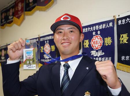 新井監督のサインが入ったドラフト会議のＩＤを手に、笑顔を見せる広島５巡目指名の明大・光弘帆高（撮影・吉澤敬太）