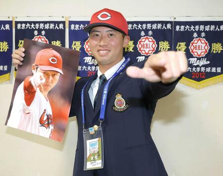 新井監督のサインが入ったドラフト会議のＩＤを胸に、笑顔でポーズを決める明大・光弘帆高（撮影・吉澤敬太）