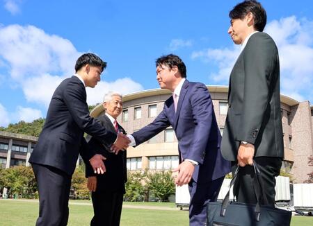 立命大・西野啓也（左）は指名あいさつに訪れた新井監督と握手をする（撮影・山口登）