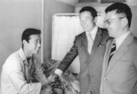 盲腸炎で入院中のため病床で入団契約を終え、当時の木下強三（中央）、木庭教（右）両スカウトと握手を交わす池谷公二郎さん＝１９７３年１１月