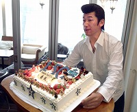 25日の誕生日を前に用意されたバースデーケーキを手に笑顔を見せる三浦