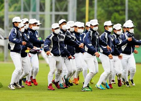 　マスクをつけグラウンドコートを着て練習する大阪桐蔭高校野球部＝１５年６月