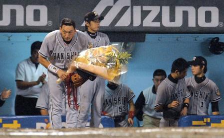 ０５年８月２５日（広島１６回戦）、今岡の満塁弾で生還し、通算１０００得点を達成した金本は花束を手にファンに頭を下げる＝広島