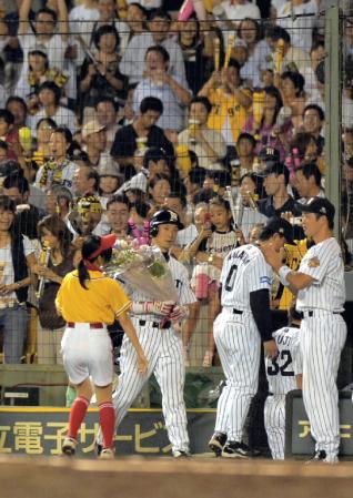 ０５年９月９日（広島１７回戦）、金本はソロホーマーを放ち通算１０００打点を達成、花束で祝福される＝甲子園