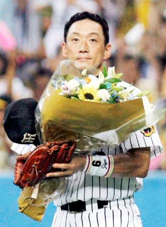 　１０００試合連続フルイニング出場を達成し、花束を手にする阪神の金本知憲外野手＝06年８月15日、京セラドーム