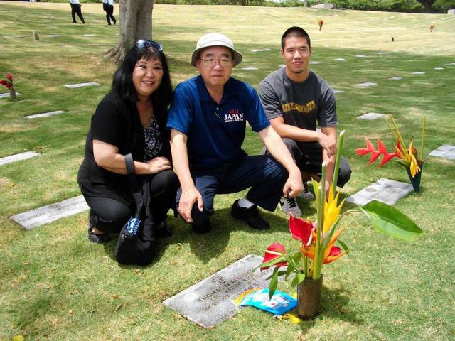 　高校選抜チームのホストを務めたトム・キヨサキさんのお墓参りをする筆者（中央）とご遺族