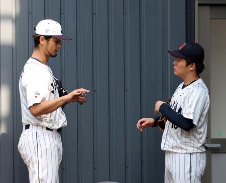 　ダルビッシュ（左）は投球練習を終えた山本にアドバイスする（撮影・山口登）