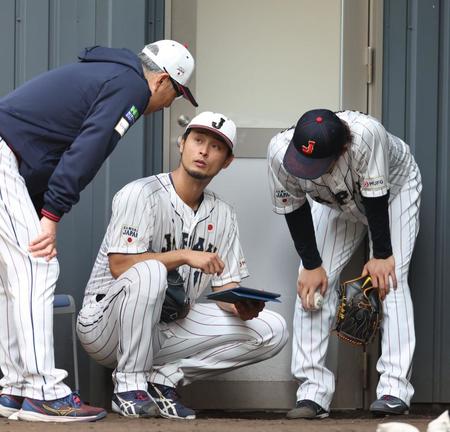 　ダルビッシュ（中央）は山本（右）の投球データを確認する（撮影・山口登）
