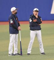 　練習中に清水外野守備走塁コーチ（左）と話し込む栗山監督（撮影・伊藤笙子）