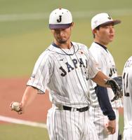 　栗林（奥）から伝授されたフォークの握りを確認するダルビッシュ（撮影・伊藤笙子）