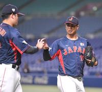 　中日との合同練習で好投し、村上（左）とフォークの握りでタッチする宇田川（撮影・伊藤笙子）