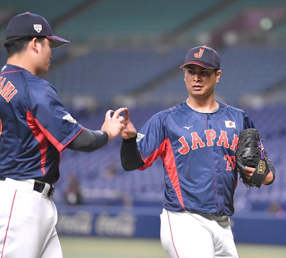　中日との合同練習で好投し、村上（左）とフォークの握りでタッチする宇田川（撮影・伊藤笙子）