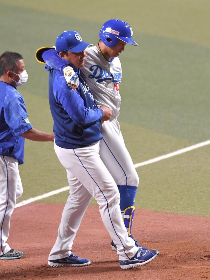 　ダルビッシュの投球を右膝に受け、抱えられるようにベンチへ下がる岡林（中央）＝撮影・伊藤笙子