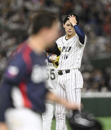 　死球を与えたチェコのエスカラ（左）を心配そうに見つめる日本先発の佐々木朗希＝１１日、東京ドーム