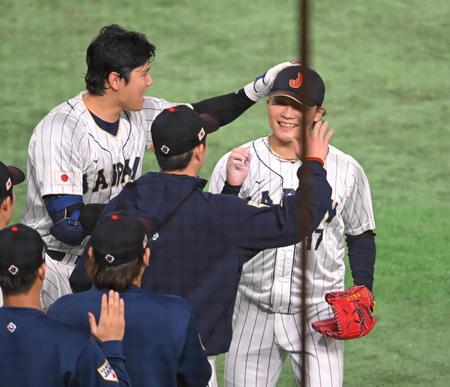 　５回途中から好リリーフを見せて大谷（左）に頭をなでられる伊藤（撮影・堀内翔）