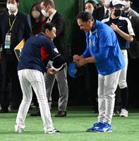 　健闘をたたえ合う栗山監督とピアザ監督（撮影・金田祐二）