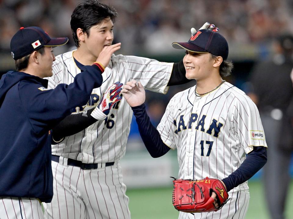 　５回の投球を終え、大谷（中）に迎えられる伊藤