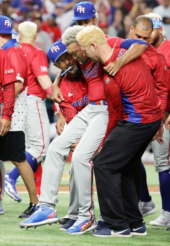 　歓喜の輪の中で負傷し、運ばれるプエルトリコのディアス（ゲッティ＝共同）