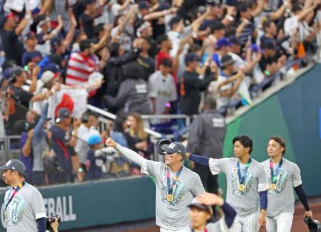 　世界一に輝き、ファンの大歓声に手を挙げて応えるヌートバー（中央）ら侍ジャパン＝２２日