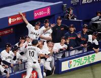 ２回裏、ソロ本塁打を放った佐々木（手前）を手を上げて迎える大谷